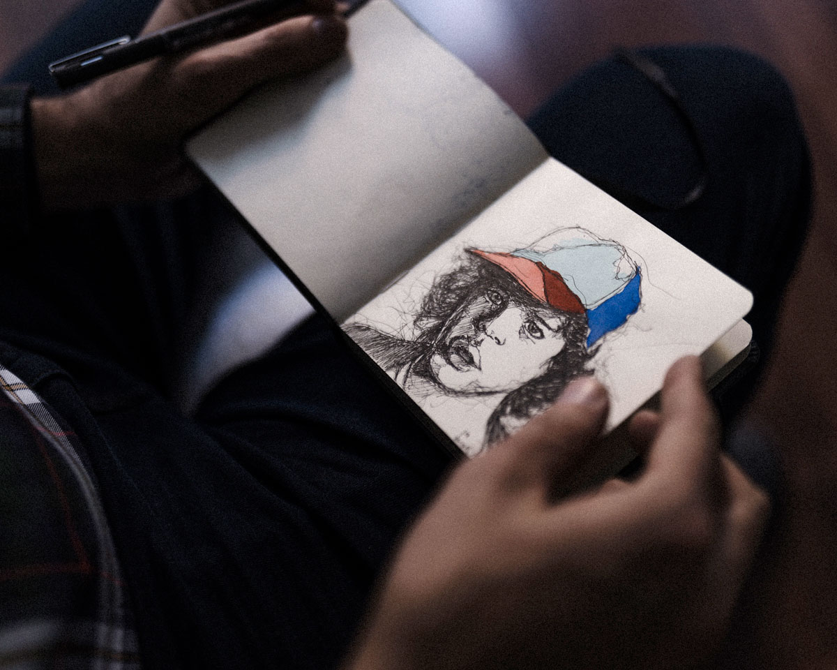 Muestra una libreta de dibujo con un personaje e de la tele